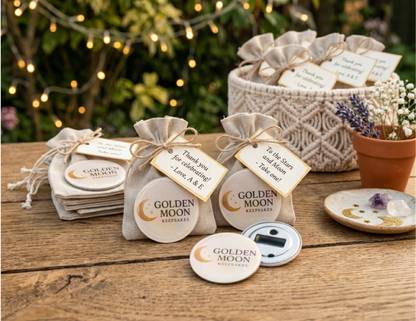 "Golden Moon Keepsakes" bottle opener wedding favor mockup on a rustic table with personalized tags, burlap bags, and a macramé basket under warm garden lights. One opener shows its magnetic back.