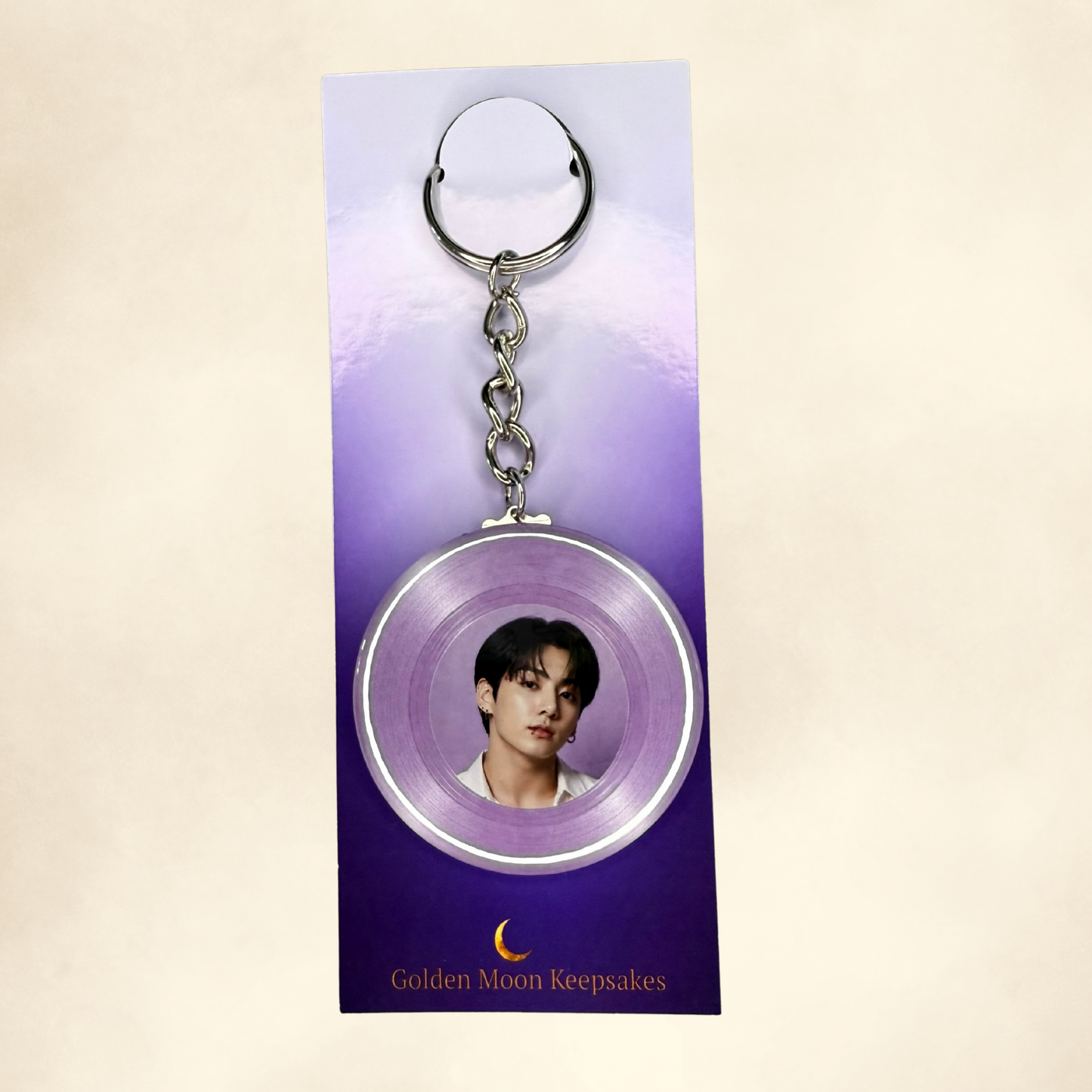 Keychain with a circular pendant featuring a person's face on a purple card with 'Golden Moon Keepsakes' text.