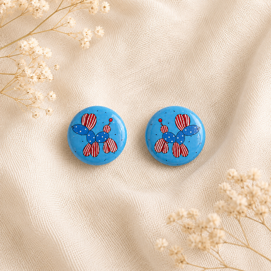 Pair of colorful 1-inch round balloon dog graphic stud earrings arranged on a clean backdrop, featuring glossy protective protective surfaces and secure metal flat pad post backings.