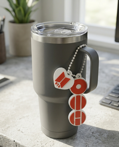 Gray travel mug with a keychain on a desk