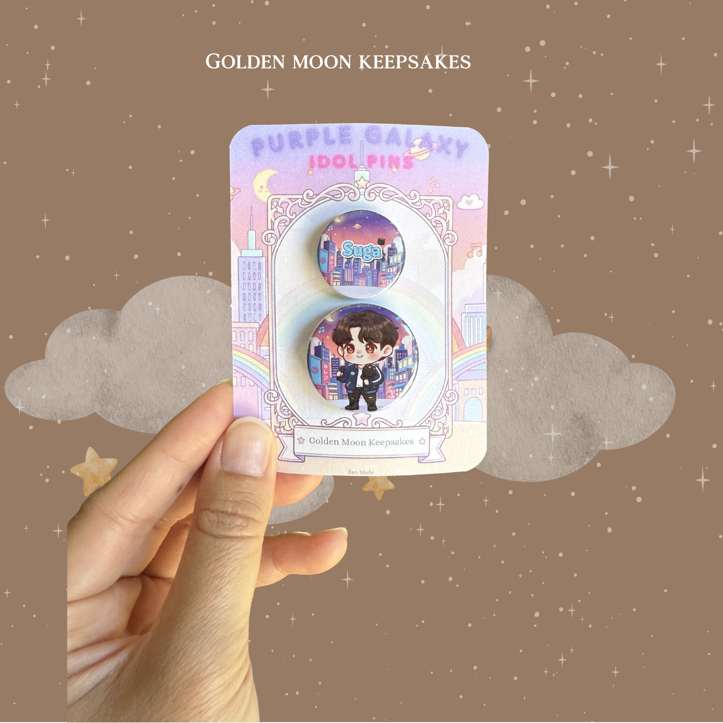 Hand holding a packaging of 'Purple Galaxy Idol pins' Suga from BTS with a starry background.
